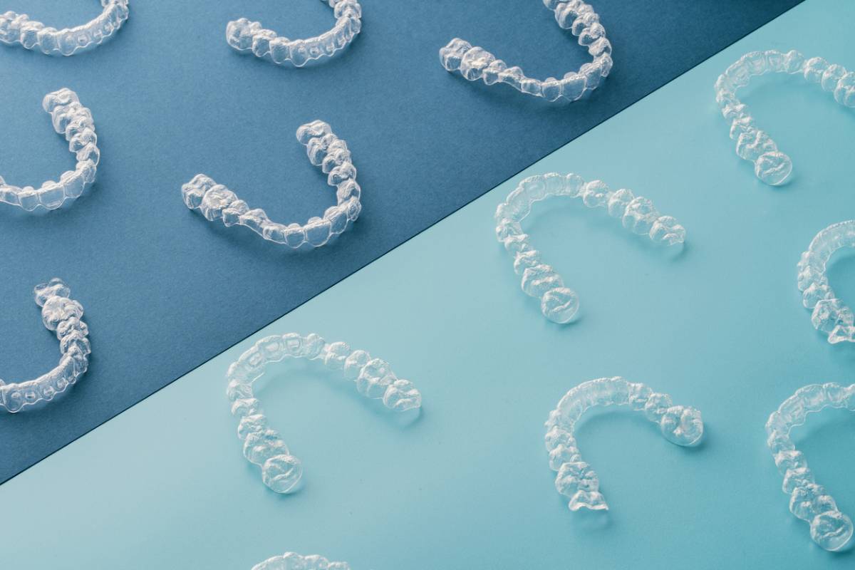 Clear plastic teeth arranged on a striking blue background,